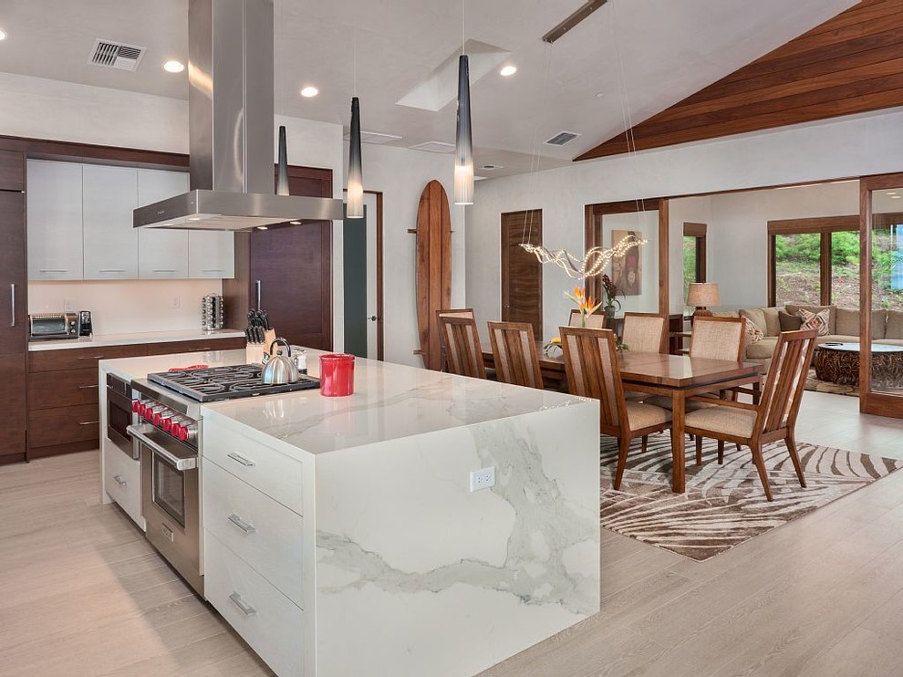 Example of a mid-sized island style light wood floor and beige floor kitchen/dining room combo design in Hawaii with white walls and no fireplace