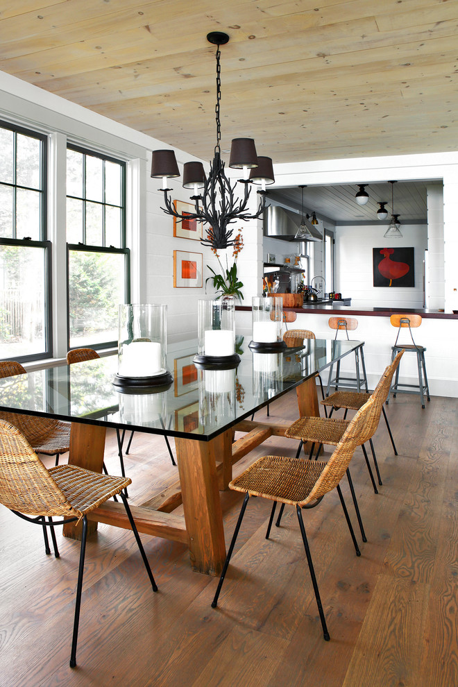 Immagine di una sala da pranzo aperta verso la cucina stile marino con pareti bianche e parquet scuro
