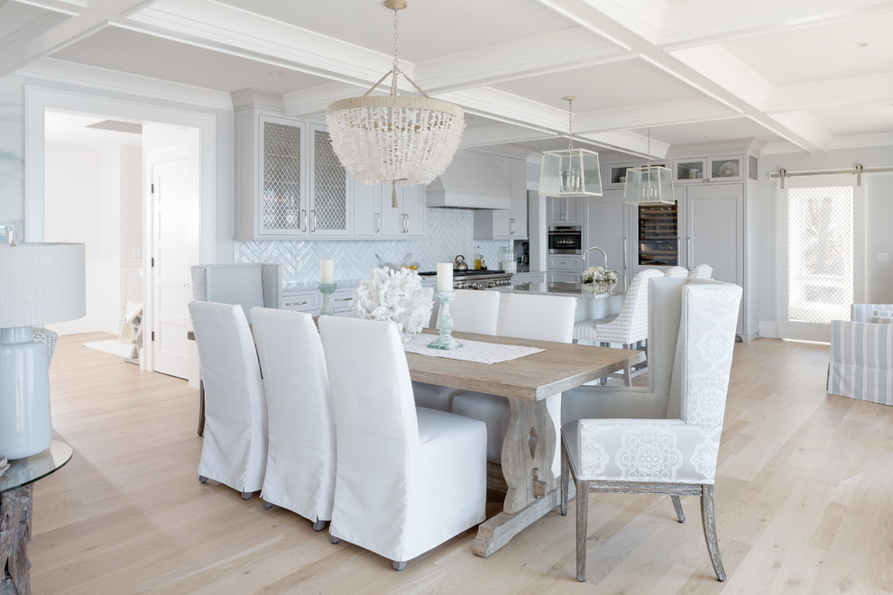 Idee per una sala da pranzo aperta verso il soggiorno stile marinaro con pareti grigie, parquet chiaro e pavimento beige