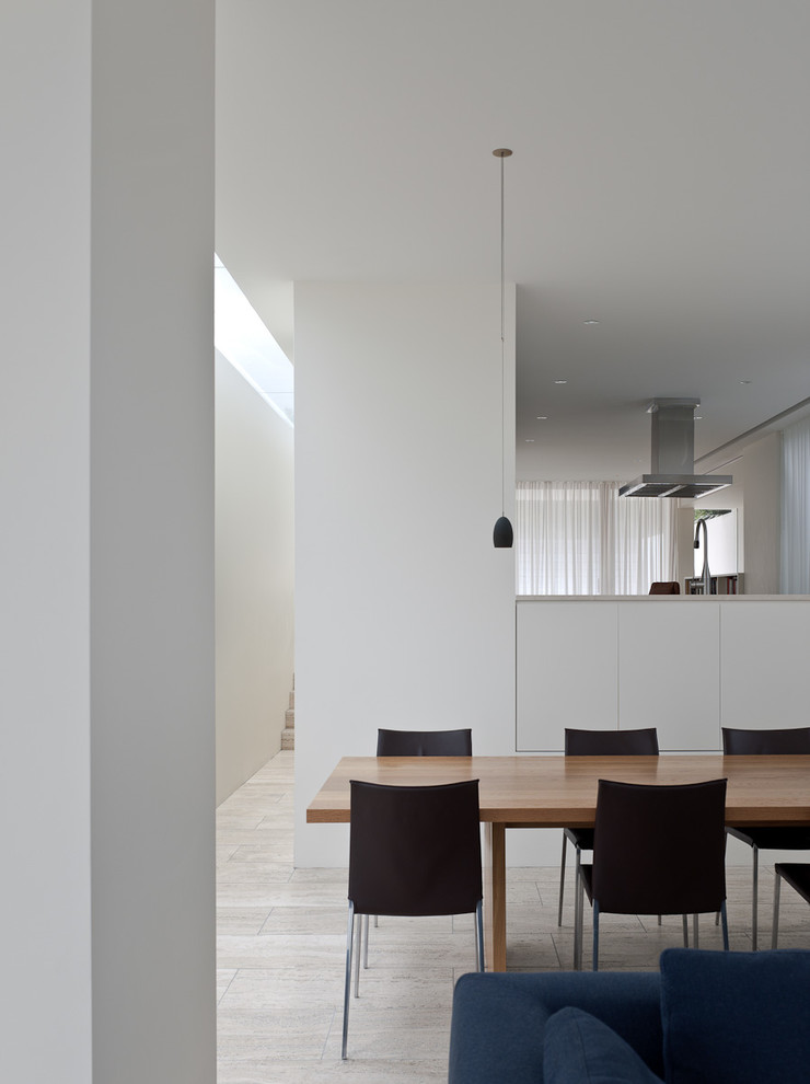 Foto di una grande sala da pranzo aperta verso la cucina design con pareti bianche e parquet chiaro