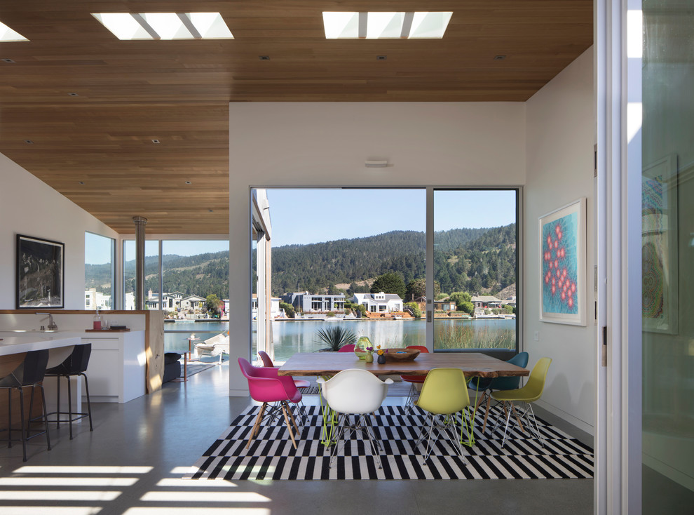 Moderne Wohnküche mit weißer Wandfarbe, Betonboden, Hängekamin und grauem Boden in San Francisco