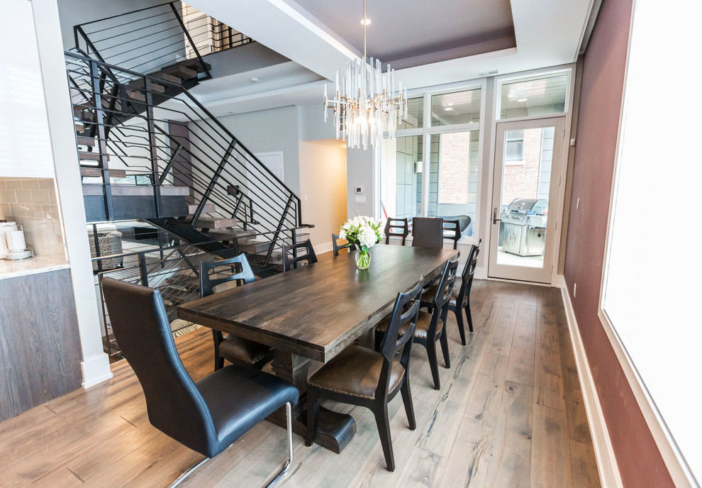 Ispirazione per una grande sala da pranzo aperta verso la cucina minimalista con pavimento in legno massello medio, pareti grigie e pavimento marrone