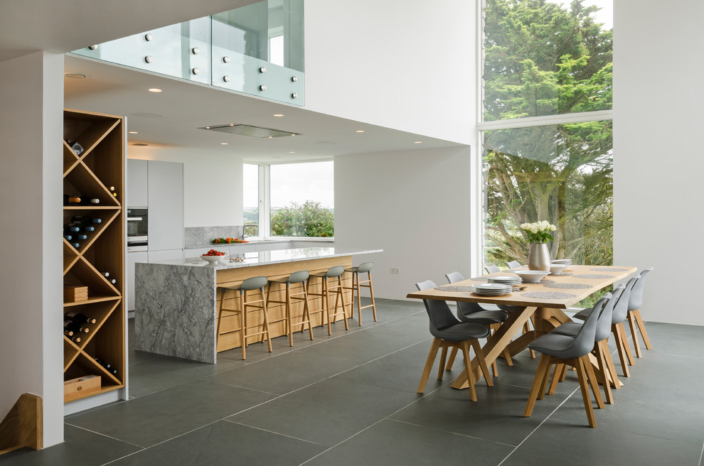 Esempio di una sala da pranzo aperta verso il soggiorno design di medie dimensioni con pavimento in ardesia e pavimento grigio