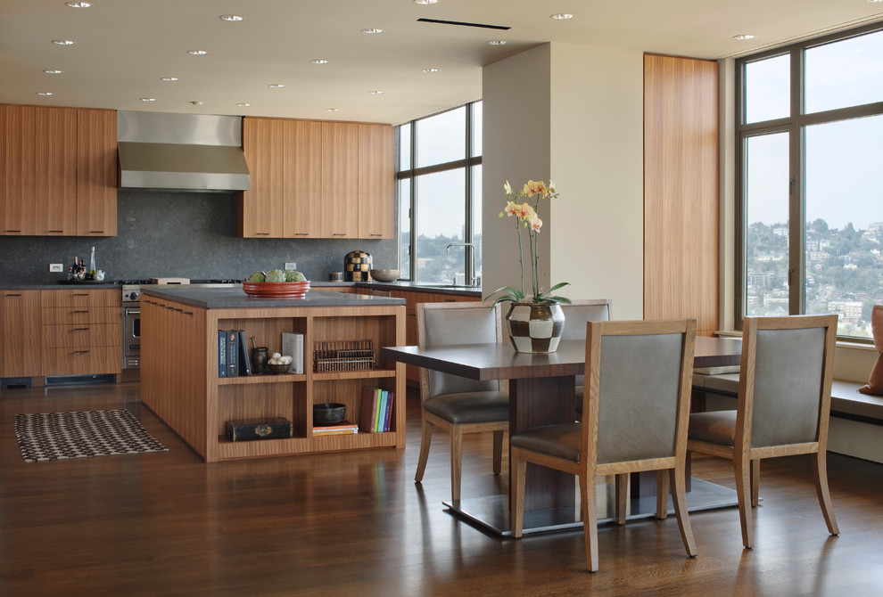 Immagine di una sala da pranzo aperta verso la cucina moderna con pareti beige e pavimento in legno massello medio