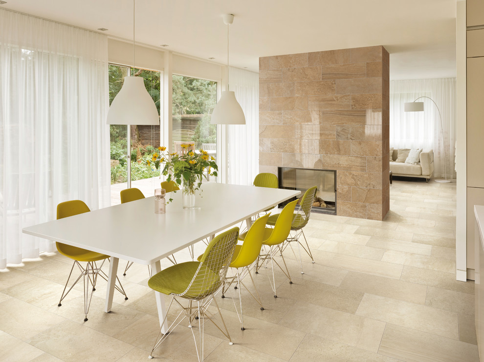 Cette image montre une grande salle à manger ouverte sur le salon design avec une cheminée double-face et un manteau de cheminée en pierre.