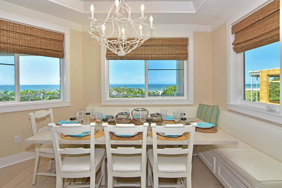 Cette image montre une petite salle à manger ouverte sur la cuisine marine avec un mur beige.