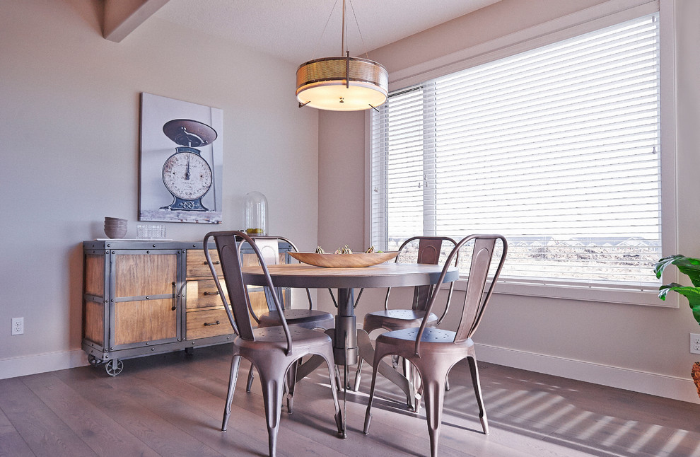 This is an example of an urban dining room in Calgary with beige walls and medium hardwood flooring.