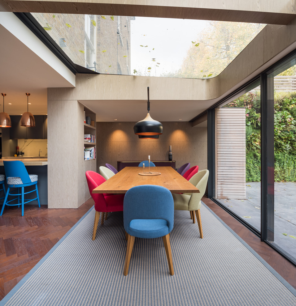 Exemple d'une salle à manger ouverte sur la cuisine tendance de taille moyenne avec parquet foncé, un sol marron et un mur beige.