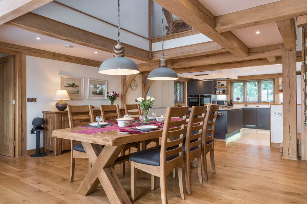 Idee per una sala da pranzo aperta verso la cucina rustica di medie dimensioni con pareti bianche, pavimento in legno massello medio e pavimento beige