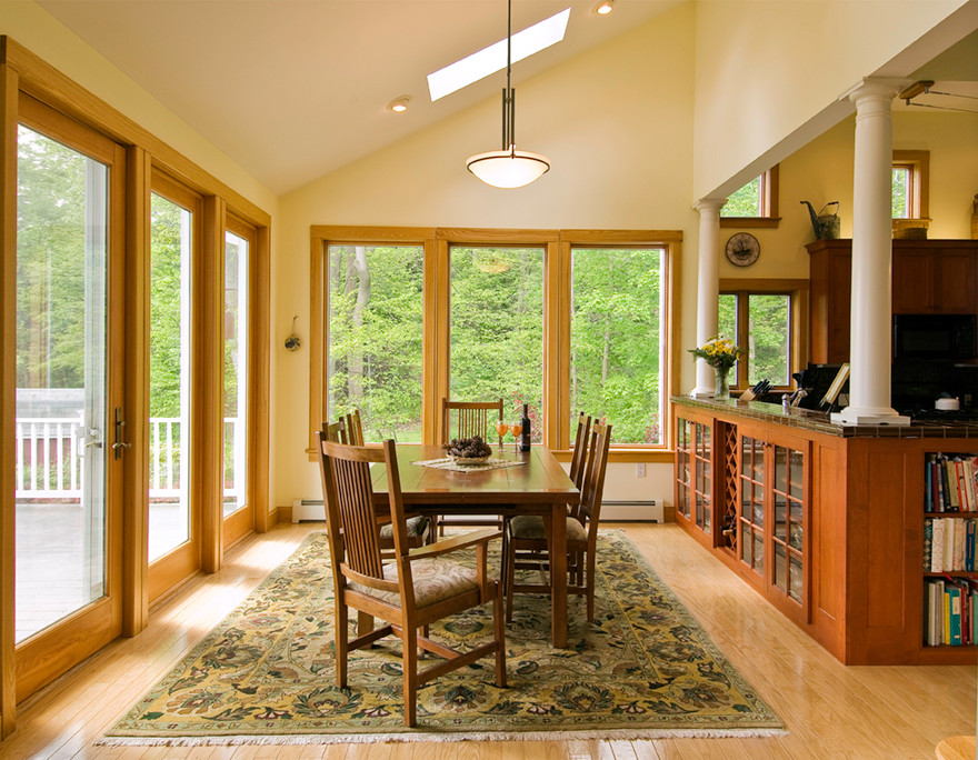 Foto di una sala da pranzo aperta verso la cucina tradizionale di medie dimensioni con pareti gialle e pavimento in legno massello medio