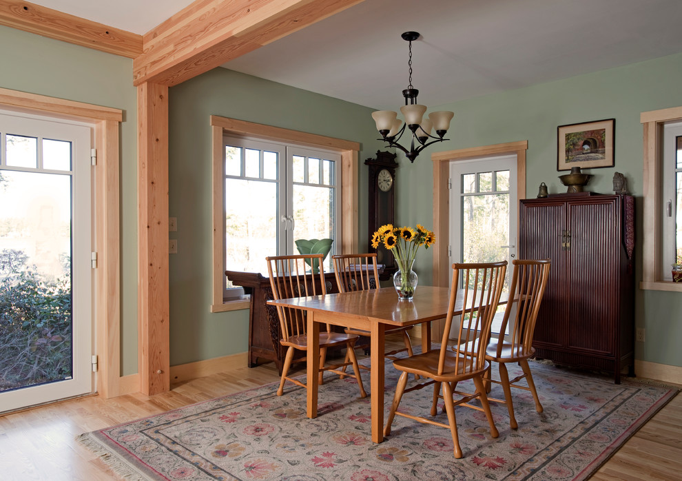 Example of a transitional medium tone wood floor and brown floor dining room design in Boston with green walls