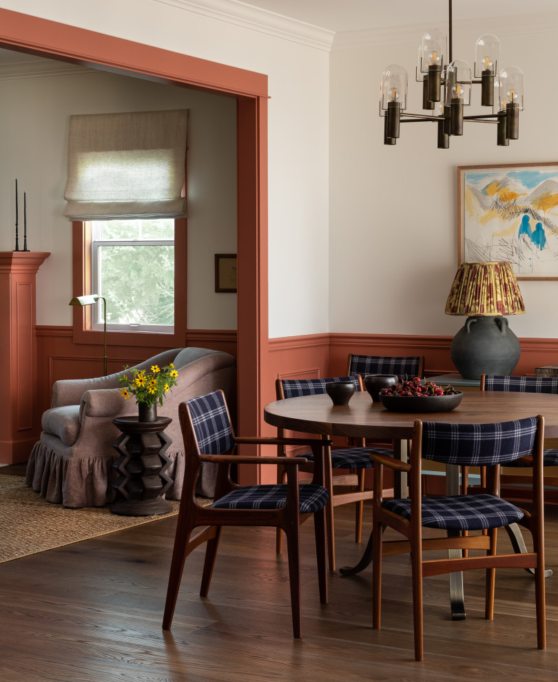 Cette photo montre une salle à manger chic avec un mur blanc, parquet foncé, un sol marron et boiseries.