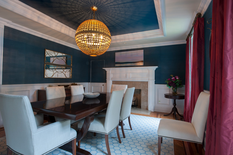 Ispirazione per una sala da pranzo chic chiusa e di medie dimensioni con pareti blu, pavimento in legno massello medio, camino classico e cornice del camino in pietra