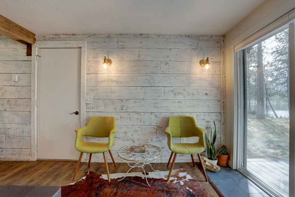 Foto di una sala da pranzo aperta verso il soggiorno stile rurale di medie dimensioni con pareti bianche, pavimento in laminato e pavimento marrone