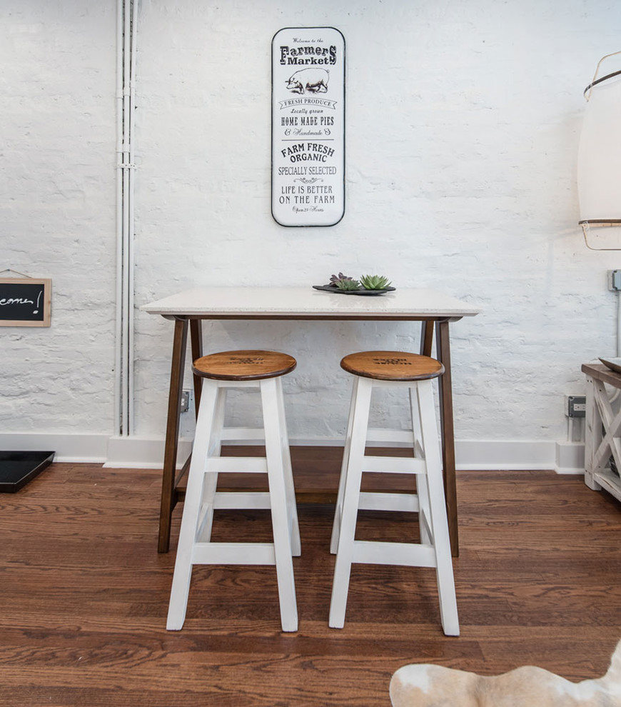 Immagine di una sala da pranzo aperta verso la cucina design di medie dimensioni con pareti bianche, pavimento in legno massello medio e nessun camino