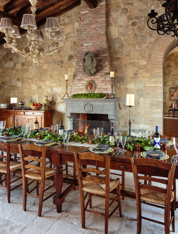 Réalisation d'une grande salle à manger ouverte sur le salon chalet avec un sol en calcaire et une cheminée standard.