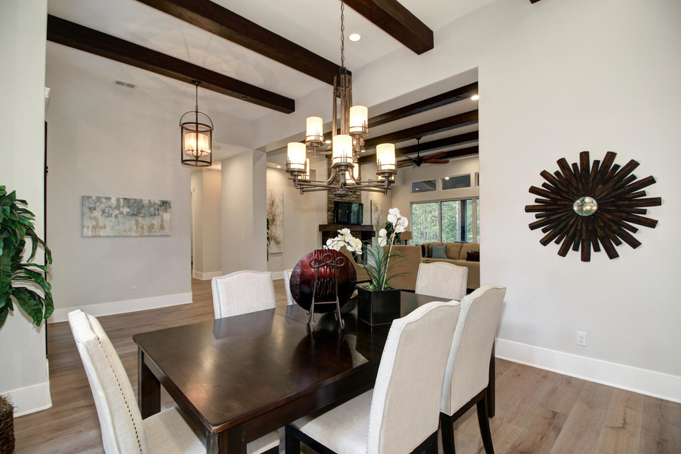 Aménagement d'une salle à manger ouverte sur le salon classique avec un mur beige et un sol en bois brun.