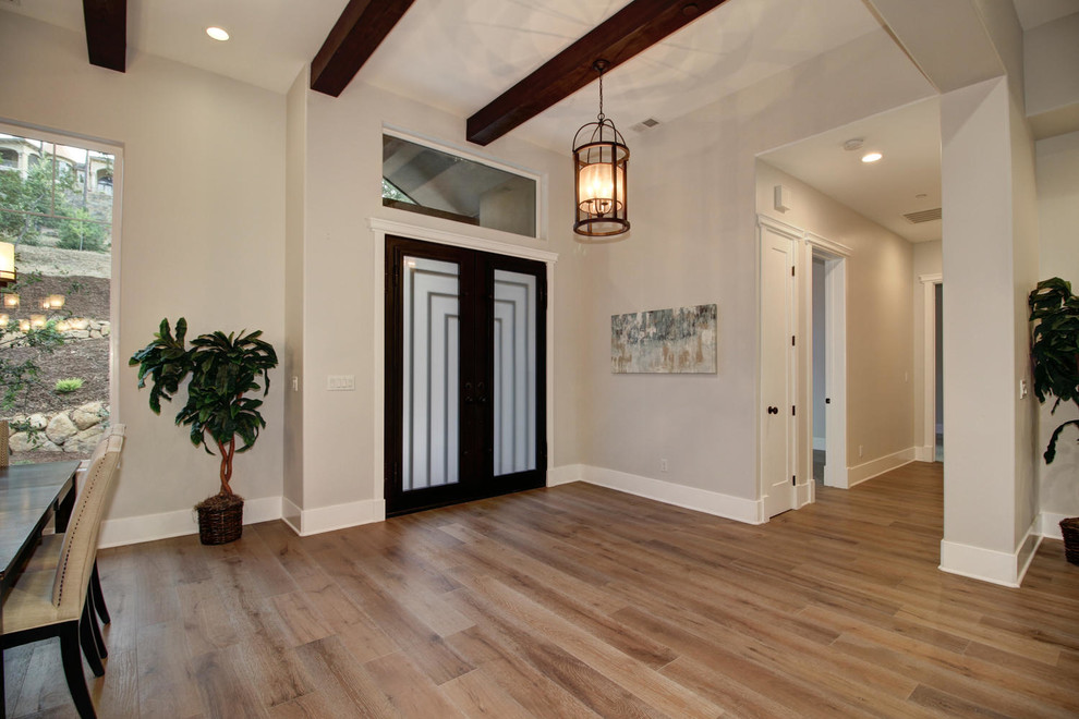 Cette photo montre une salle à manger ouverte sur le salon chic avec un mur beige et un sol en bois brun.