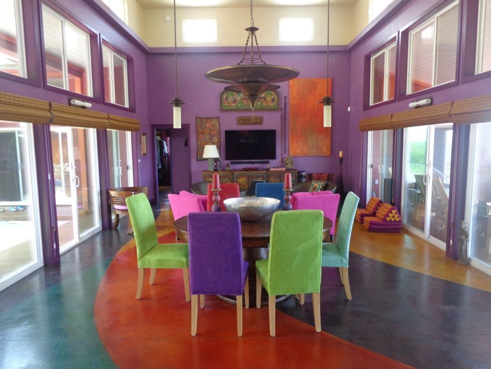 Esempio di una sala da pranzo con pareti viola e pavimento in cemento