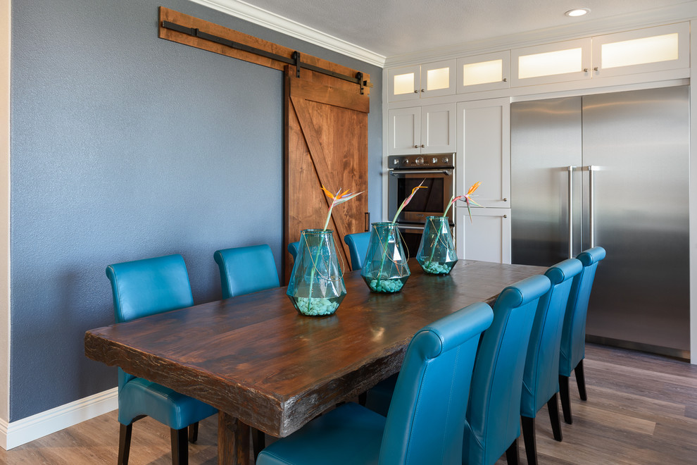 Idées déco pour une salle à manger ouverte sur la cuisine classique avec un mur bleu et un sol en bois brun.