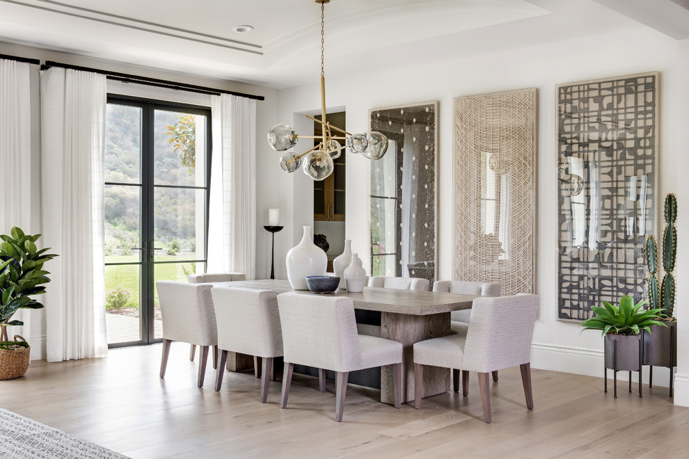 Cette image montre une salle à manger ouverte sur le salon traditionnelle de taille moyenne avec un mur blanc, parquet clair, un sol beige et aucune cheminée.