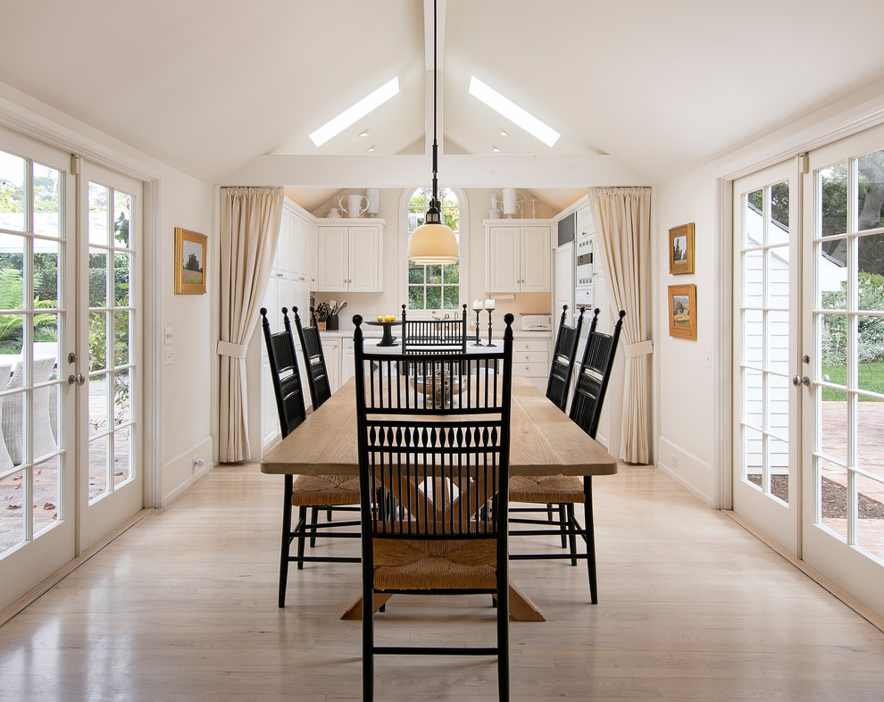 Réalisation d'une salle à manger champêtre avec un mur blanc, parquet clair et un sol beige.