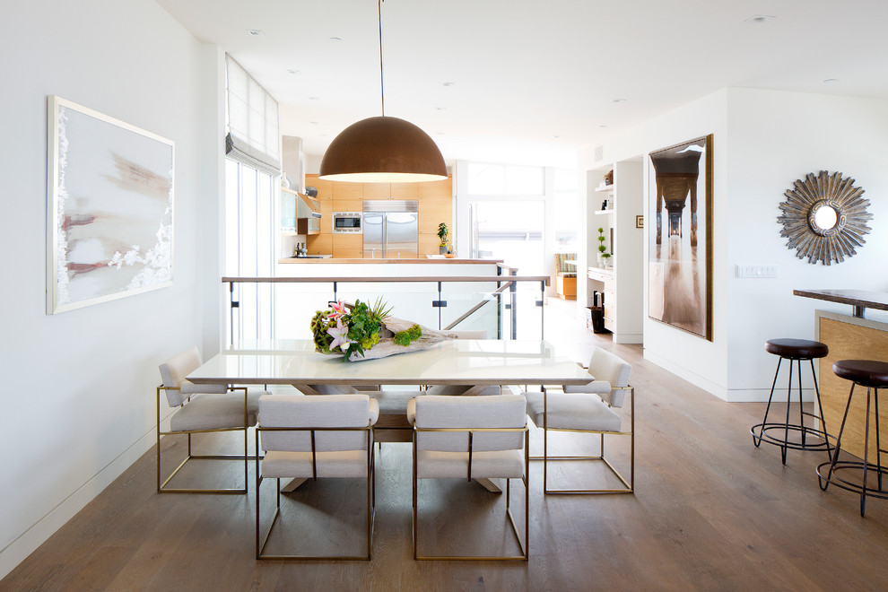 Idées déco pour une salle à manger ouverte sur la cuisine contemporaine avec un mur blanc et un sol en bois brun.