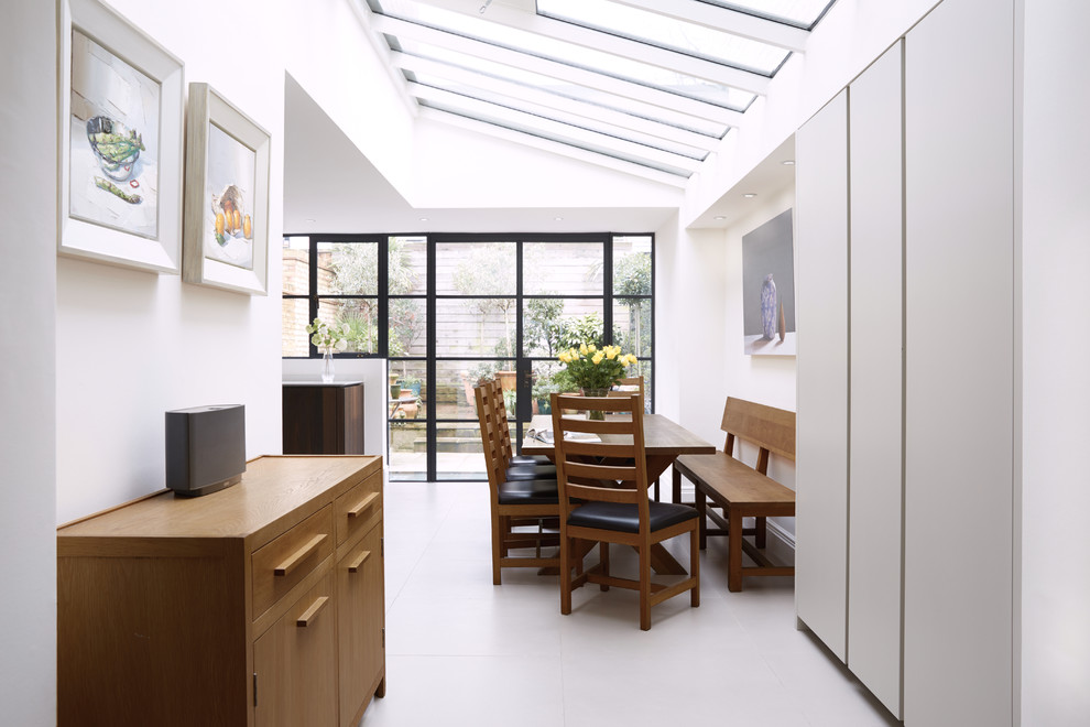 Diseño de comedor contemporáneo abierto con paredes blancas y suelo blanco