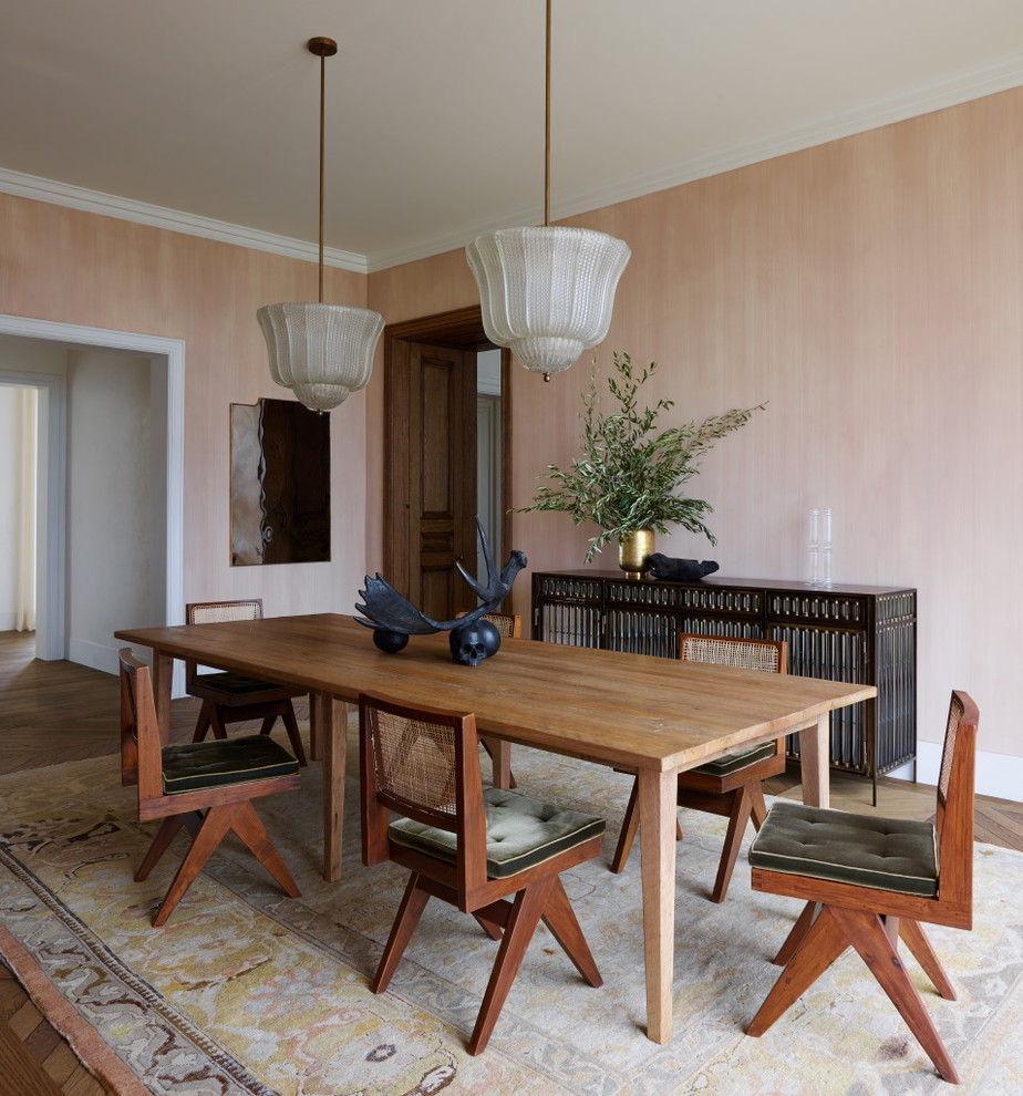 Exemple d'une salle à manger chic fermée avec un mur rose, un sol en bois brun et aucune cheminée.