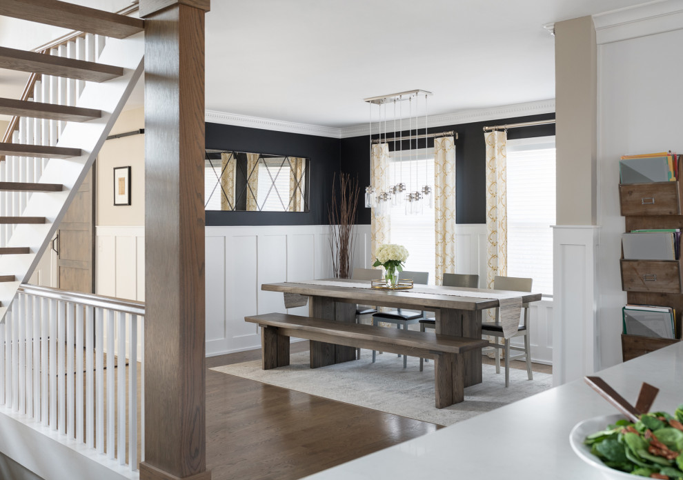 Esempio di una sala da pranzo chic di medie dimensioni con pareti nere, pavimento in legno massello medio, boiserie e pavimento marrone