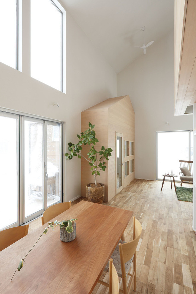 Ispirazione per una sala da pranzo aperta verso la cucina contemporanea di medie dimensioni con pareti bianche, parquet chiaro e pavimento beige