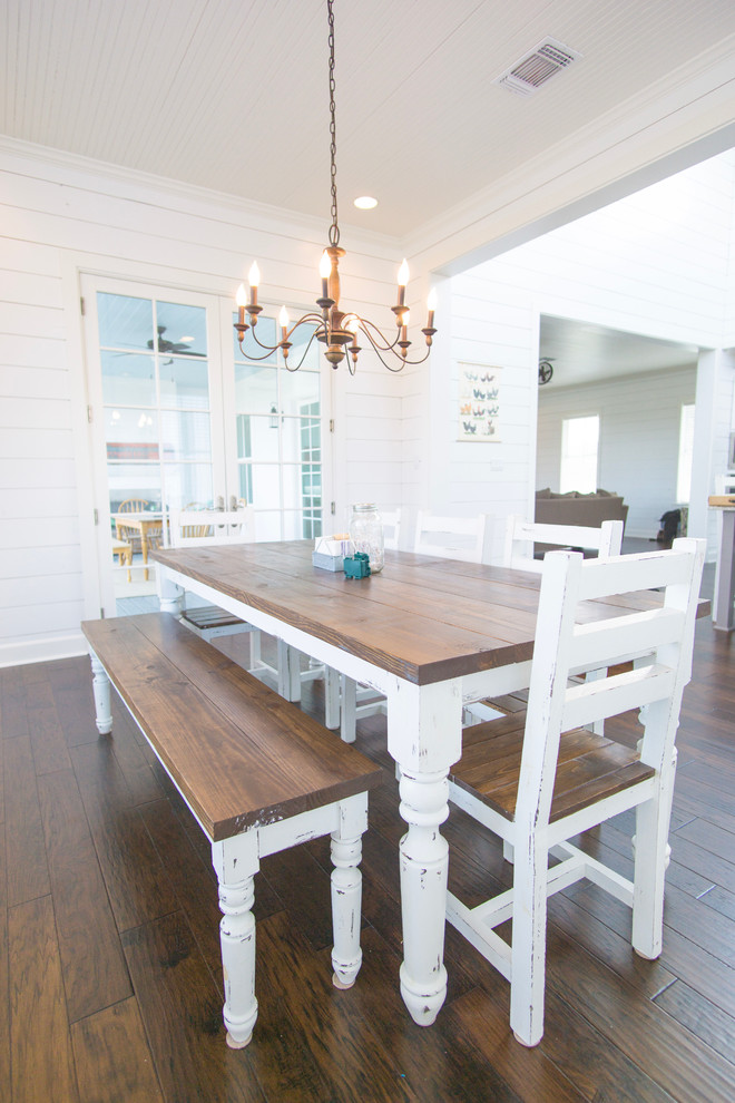Réalisation d'une salle à manger ouverte sur la cuisine champêtre de taille moyenne avec un mur blanc et un sol en bois brun.