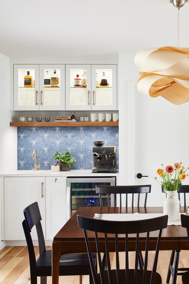 Esempio di una sala da pranzo aperta verso la cucina minimalista di medie dimensioni con pareti bianche, parquet chiaro, nessun camino e pavimento marrone