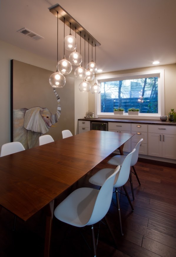 Foto di una sala da pranzo aperta verso la cucina minimalista di medie dimensioni con pareti beige, parquet scuro, nessun camino e pavimento blu