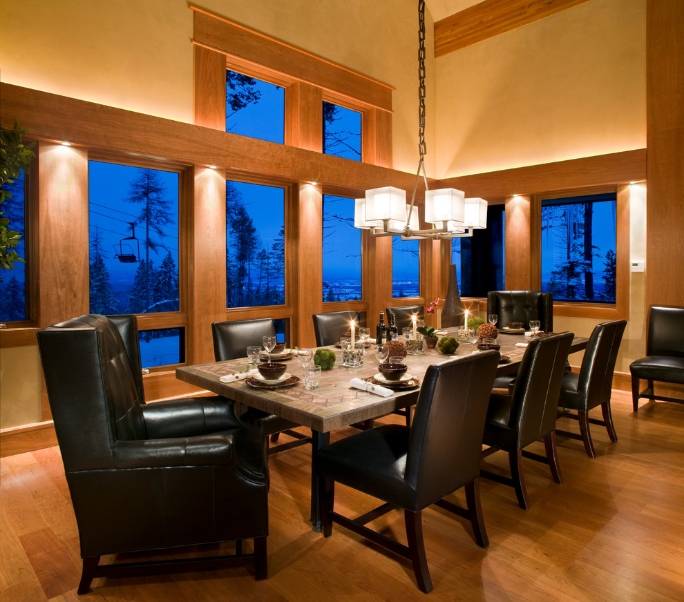 Cette image montre une salle à manger chalet fermée et de taille moyenne avec un mur beige, parquet clair, aucune cheminée et un sol marron.