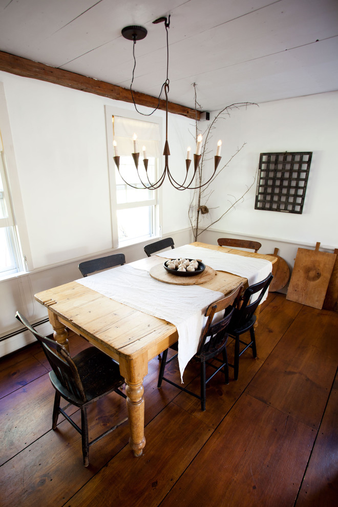 Inspiration for a country dining room in Boston with white walls and dark hardwood flooring.