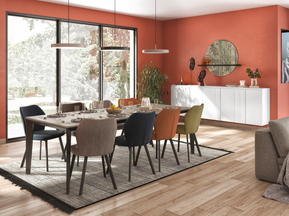 Immagine di una grande sala da pranzo design con parquet chiaro, pavimento marrone e pareti arancioni