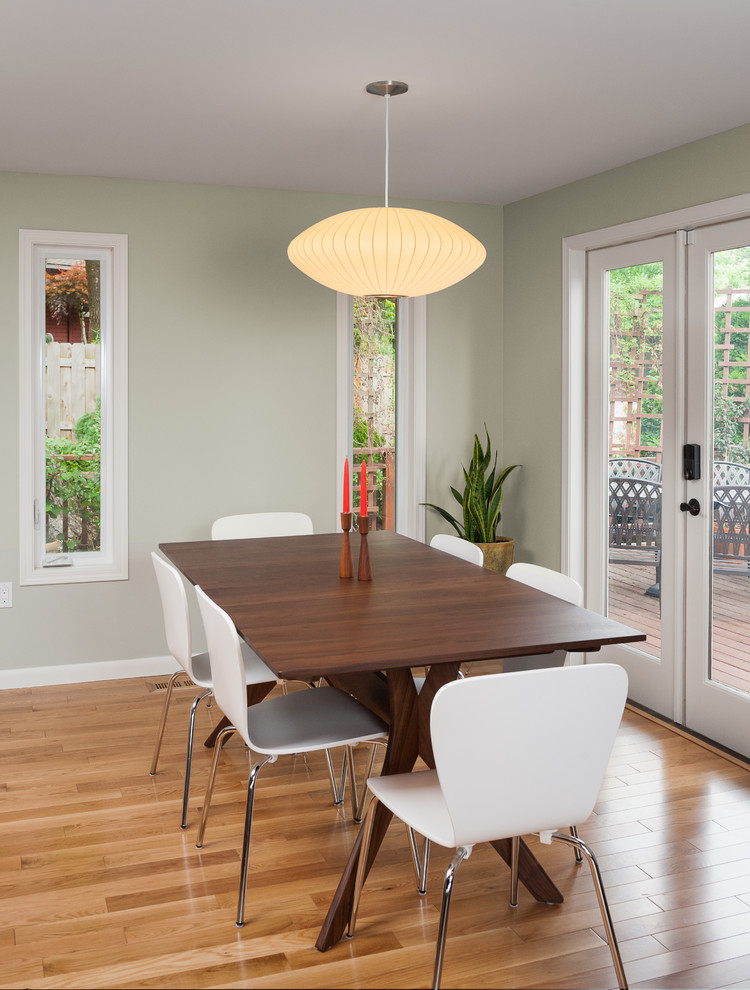Idee per una piccola sala da pranzo aperta verso la cucina moderna con pareti verdi, pavimento in legno massello medio, nessun camino e pavimento marrone