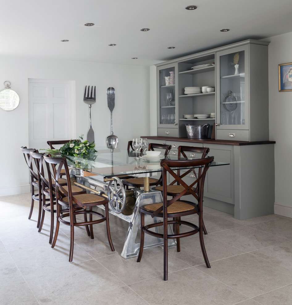 На фото: кухня-столовая среднего размера в стиле неоклассика (современная классика) с полом из известняка, серым полом и белыми стенами