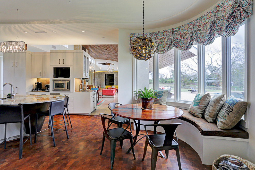 Große Moderne Wohnküche ohne Kamin mit weißer Wandfarbe, braunem Holzboden und braunem Boden in Houston