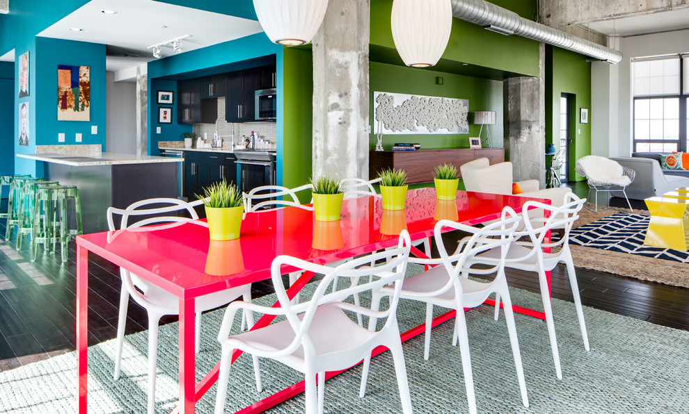 Immagine di una grande sala da pranzo aperta verso la cucina minimalista con pareti multicolore, parquet scuro e nessun camino