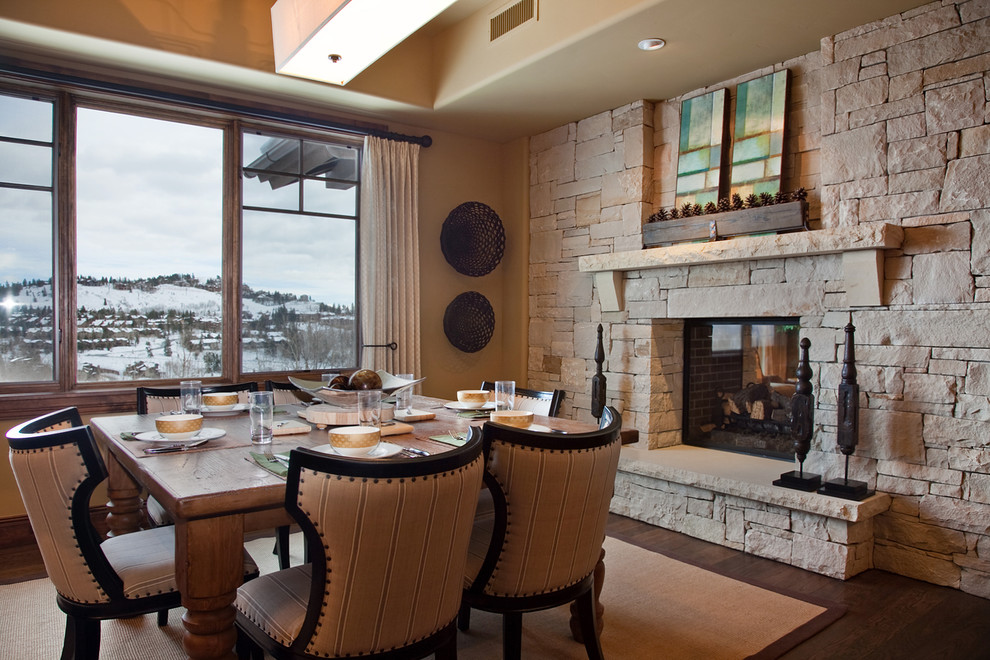 Traditional dining room in Salt Lake City with beige walls, dark hardwood flooring, a standard fireplace and a stone fireplace surround.