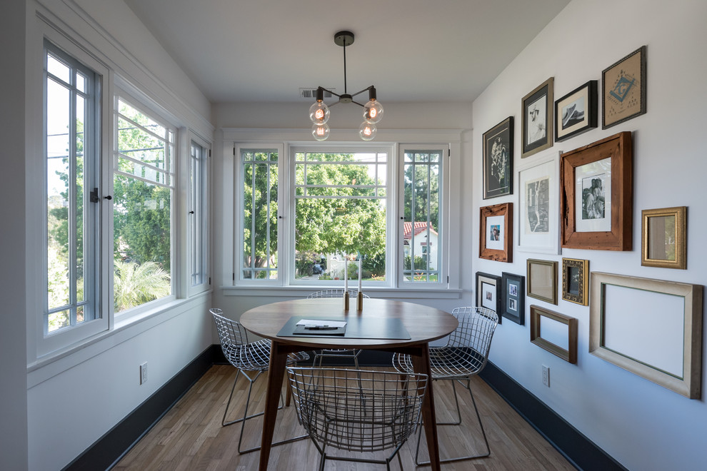 Cette image montre une salle à manger ouverte sur la cuisine craftsman de taille moyenne avec un mur blanc, parquet clair, une cheminée standard, un manteau de cheminée en carrelage et un sol multicolore.