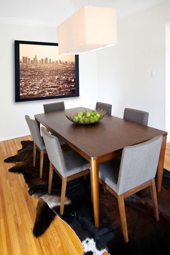 Photo of a retro dining room in Dallas with white walls and medium hardwood flooring.