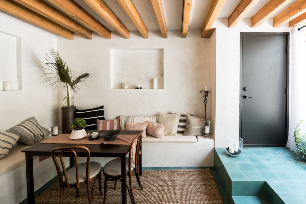 Inspiration pour une salle à manger méditerranéenne avec une banquette d'angle, un mur blanc, un sol bleu et poutres apparentes.