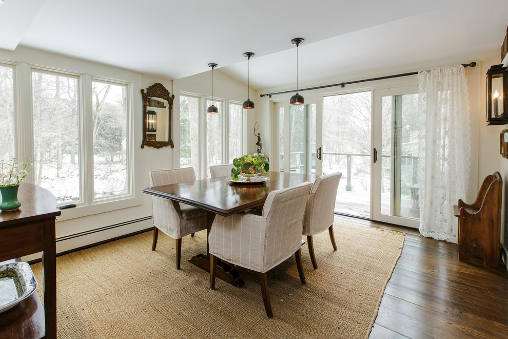 Cette photo montre une salle à manger ouverte sur la cuisine nature de taille moyenne avec un mur blanc et parquet foncé.