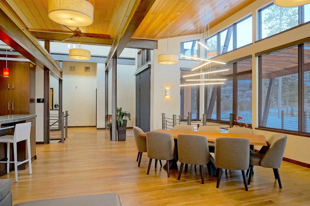Ispirazione per una sala da pranzo aperta verso la cucina minimalista di medie dimensioni con pareti beige, parquet chiaro e nessun camino