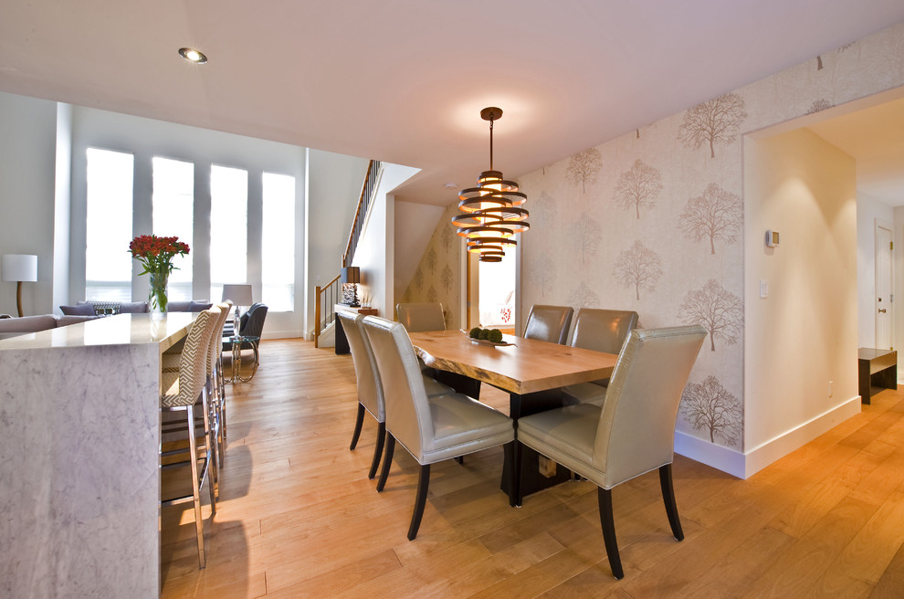 Cette photo montre une salle à manger ouverte sur le salon tendance avec un sol en bois brun.