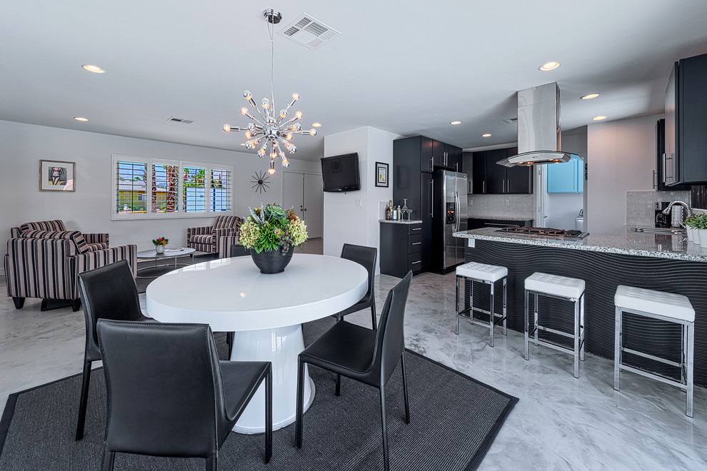 Foto di una sala da pranzo aperta verso la cucina moderna di medie dimensioni con pareti bianche e pavimento in cemento