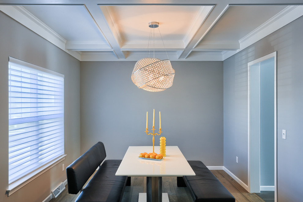 Cette image montre une salle à manger minimaliste fermée et de taille moyenne avec un mur gris et un sol en bois brun.